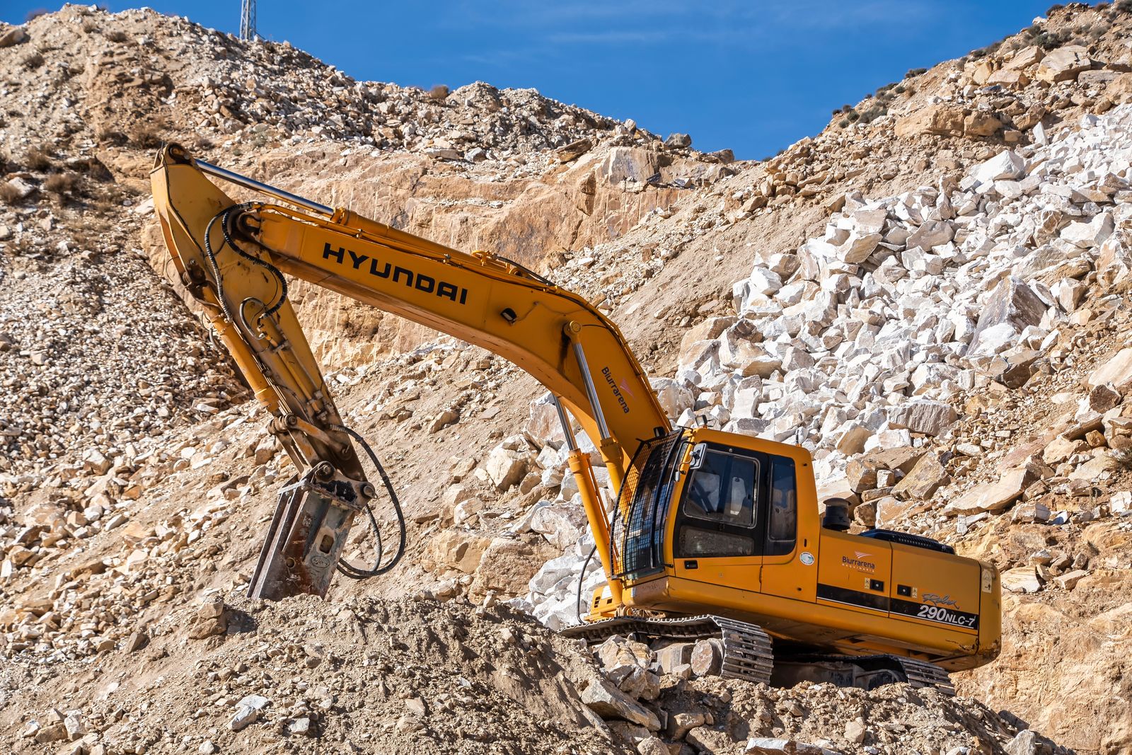 Excavator with rock breaker on a quarry site