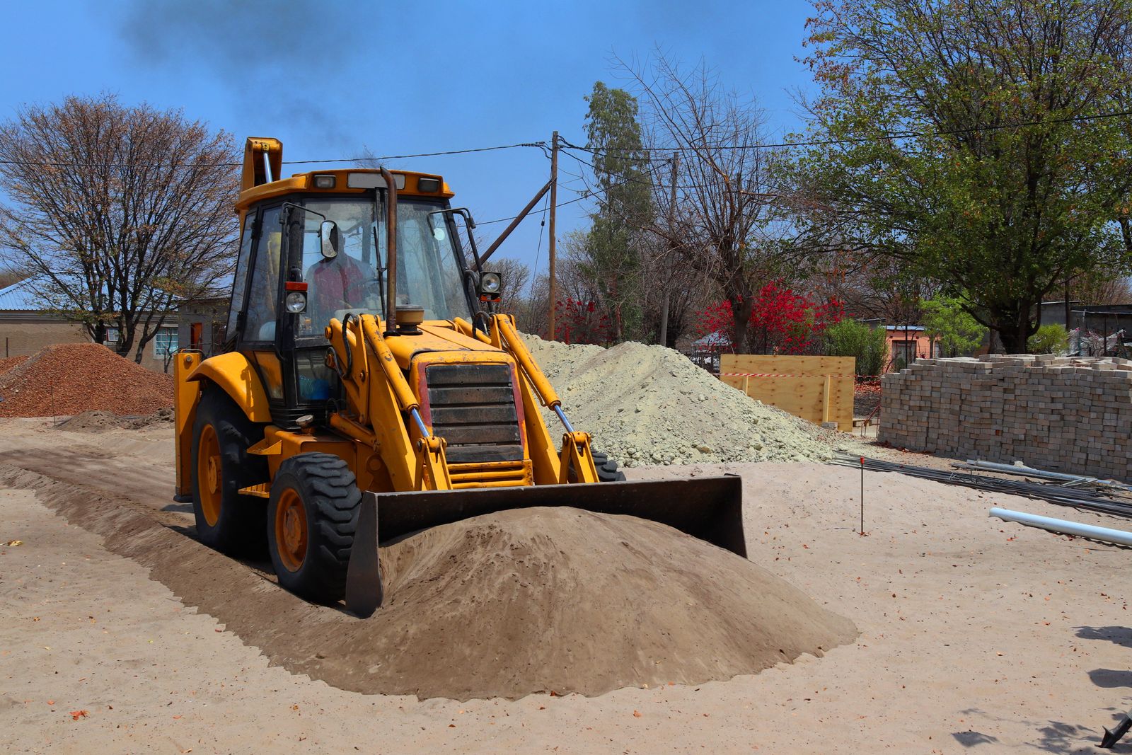 TLB backhoe loader working on a water pipeline site